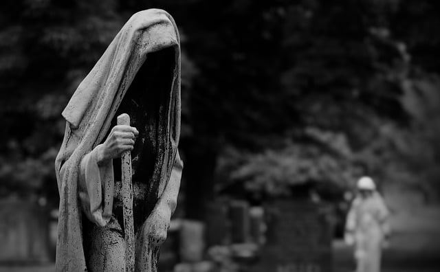 Escultura velada sobre una lápida en un cementerio, evocando el silencio y el misterio bajo tierra.