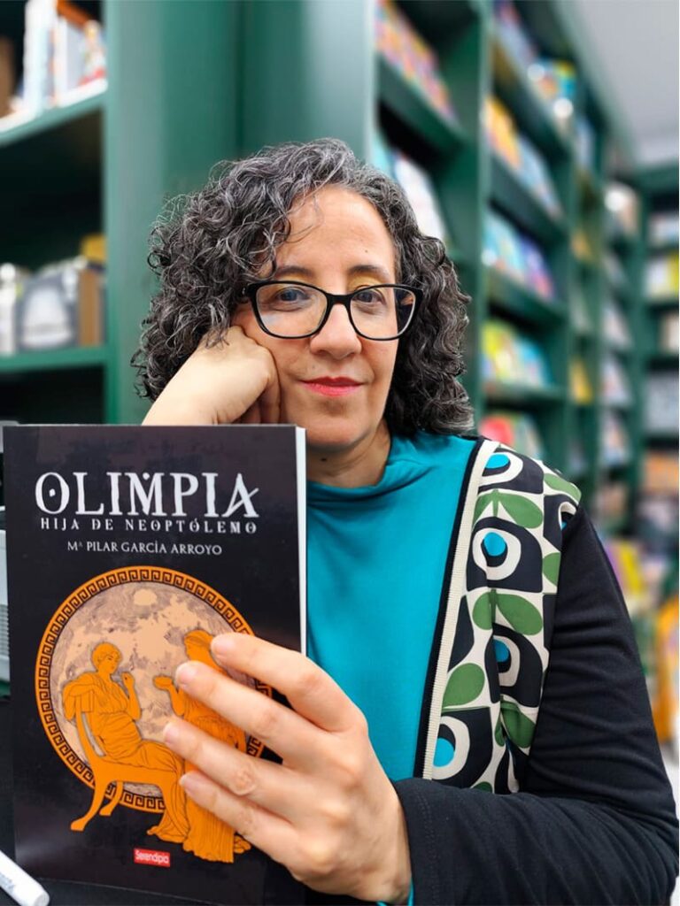 Pilar García Arroyo con la portada de su novela Olimpia, hija de Neoptólemo